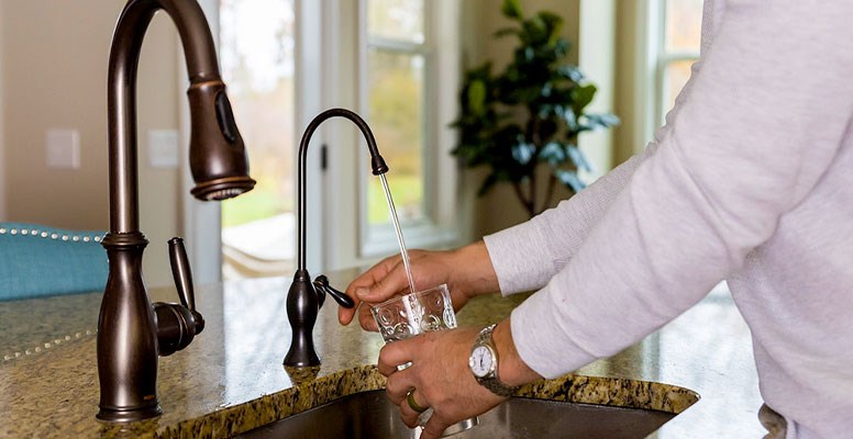 Man filling water glass a dedicated tap