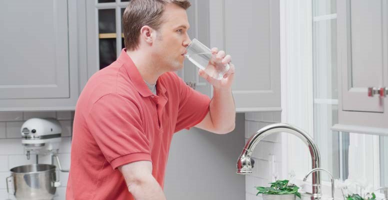 Man drinking water at sink